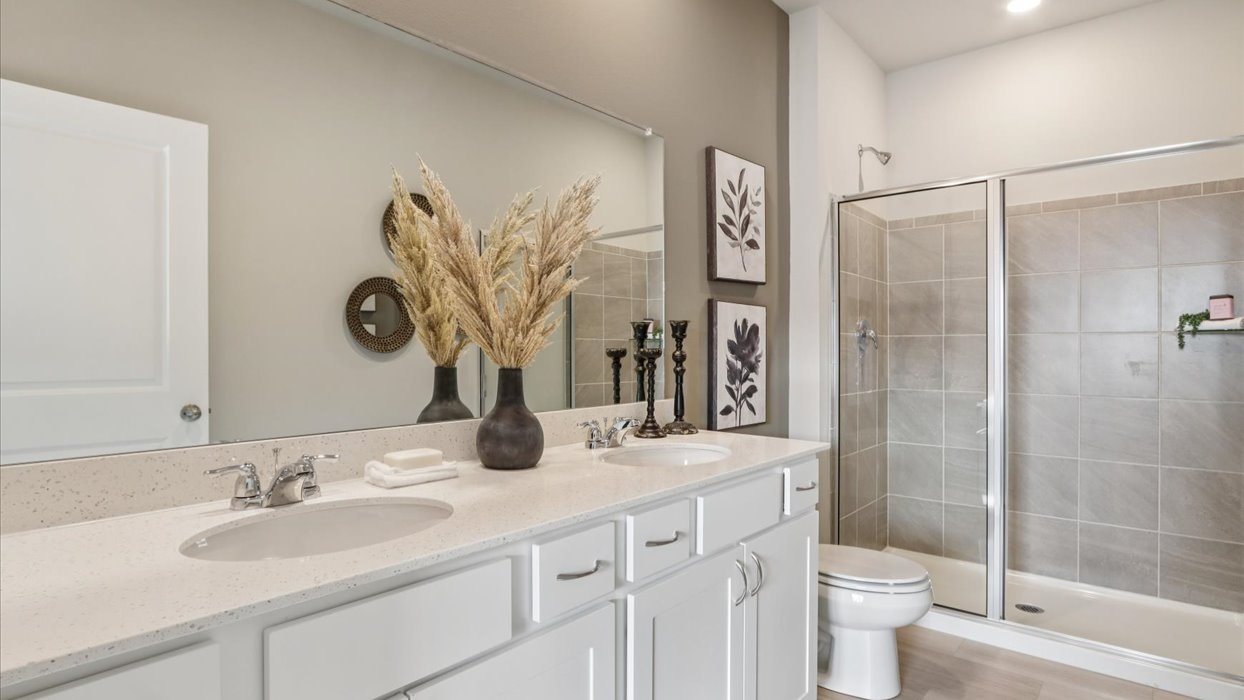 primary bathroom with large mirror and tile shower
