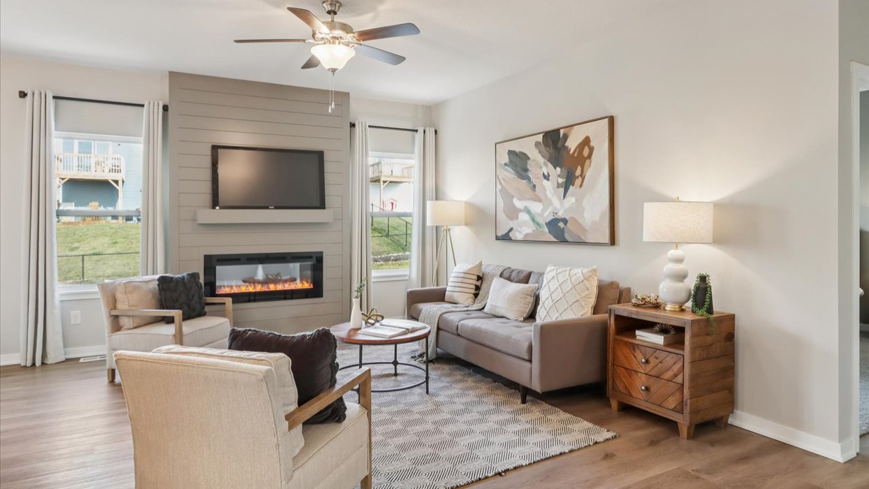 colorful living room with green accent wall and electric fireplace
