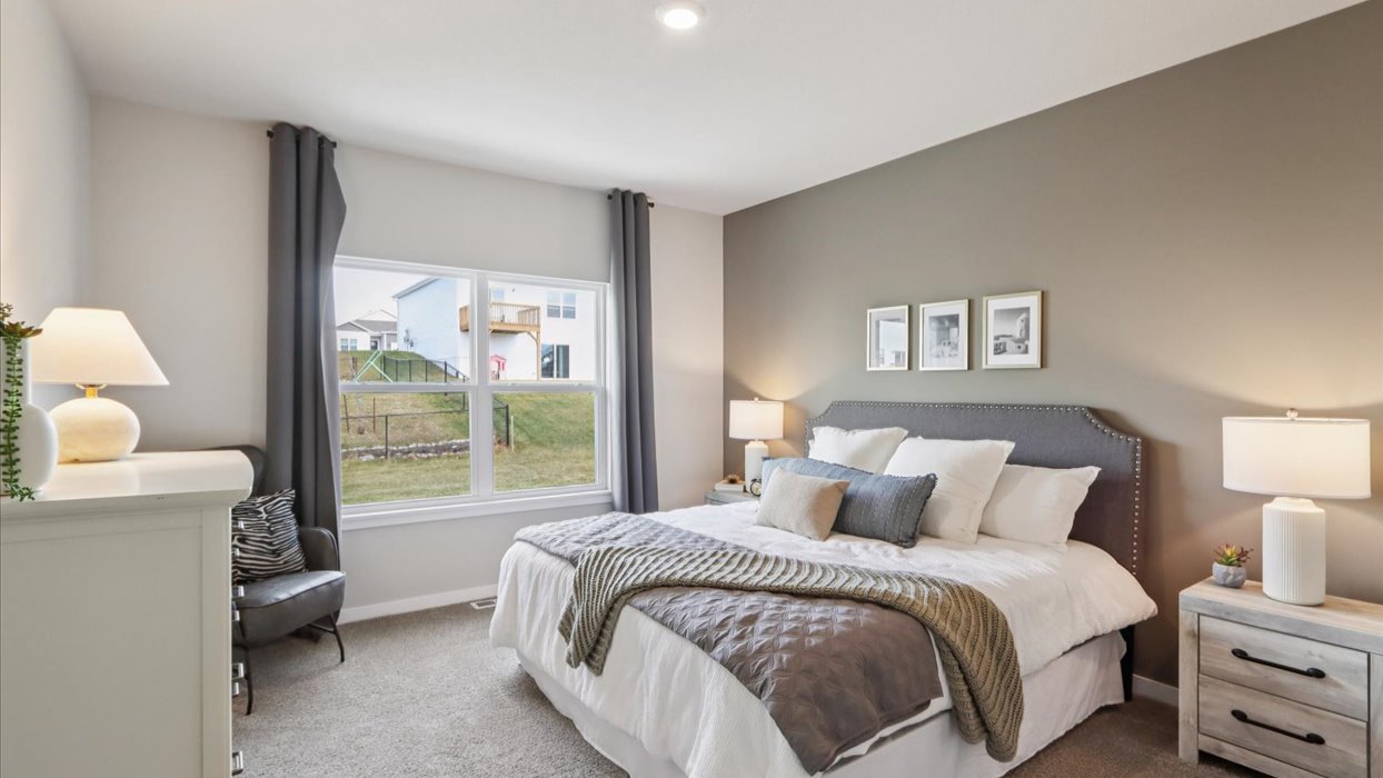 spacious primary bedroom with large window and bed with nightstands