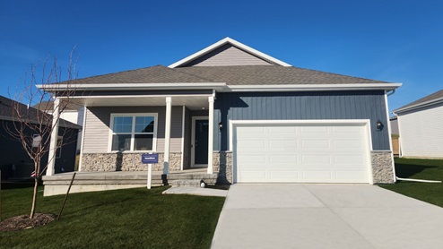 1 story Hamilton plan with blue and grey siding, covered front porch and 2 car garage