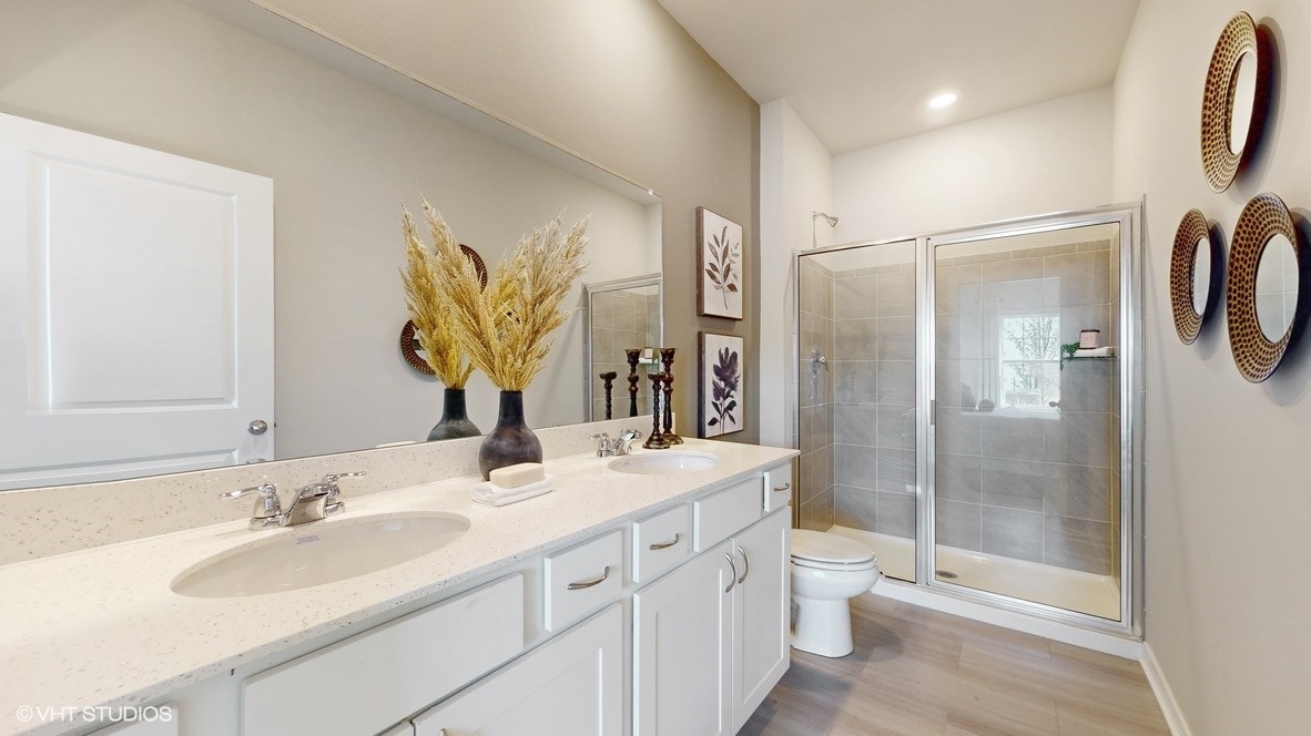 Primary bathroom with white cabinets and tile shower
