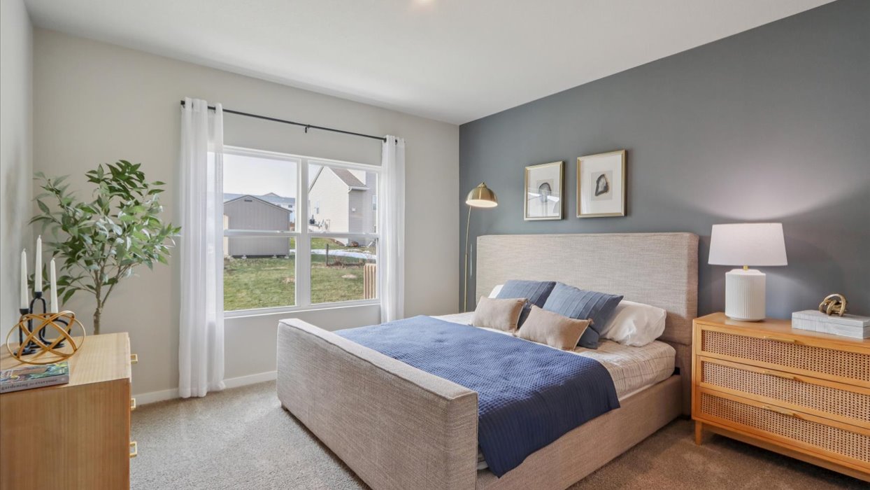 large primary bedroom with accent wall and window