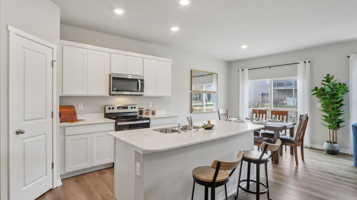 Kitchen with stainless steel appliances, quartz countertops, and white cabinetry