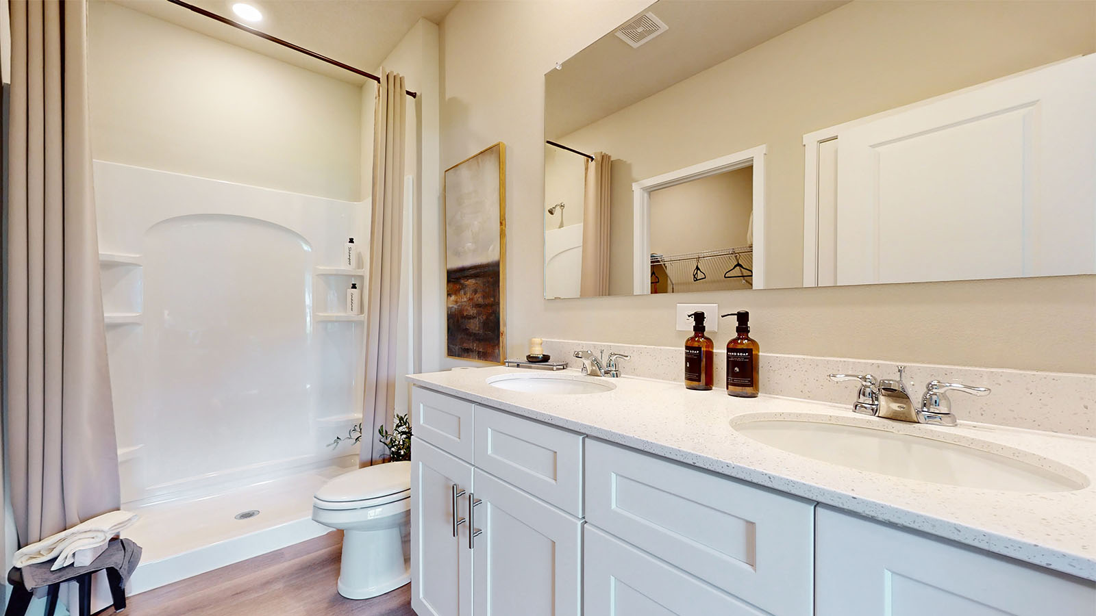 primary bathroom with large mirror and dual sinks
