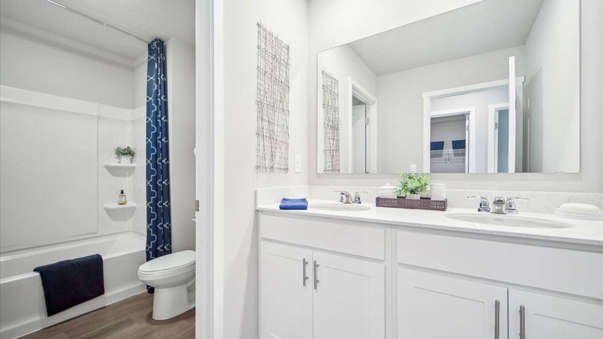 Bathroom with tub and shower combo, quartz countertops, and white vanity