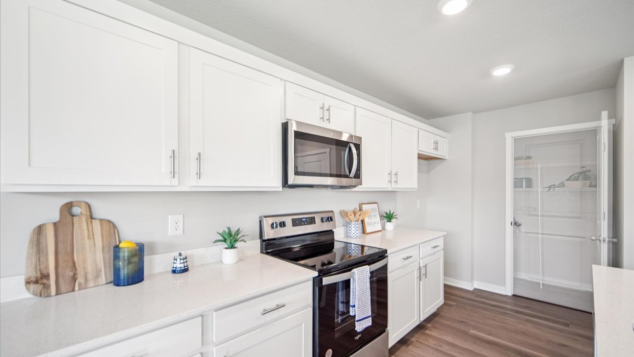 Kitchen with stainless steel appliances, quartz countertops, and white cabinetry
