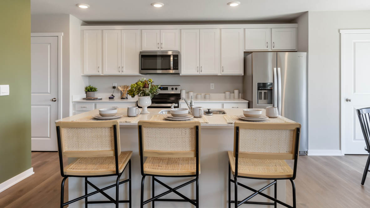 Kitchen with stainless steel appliances, quartz countertops, and white cabinetry