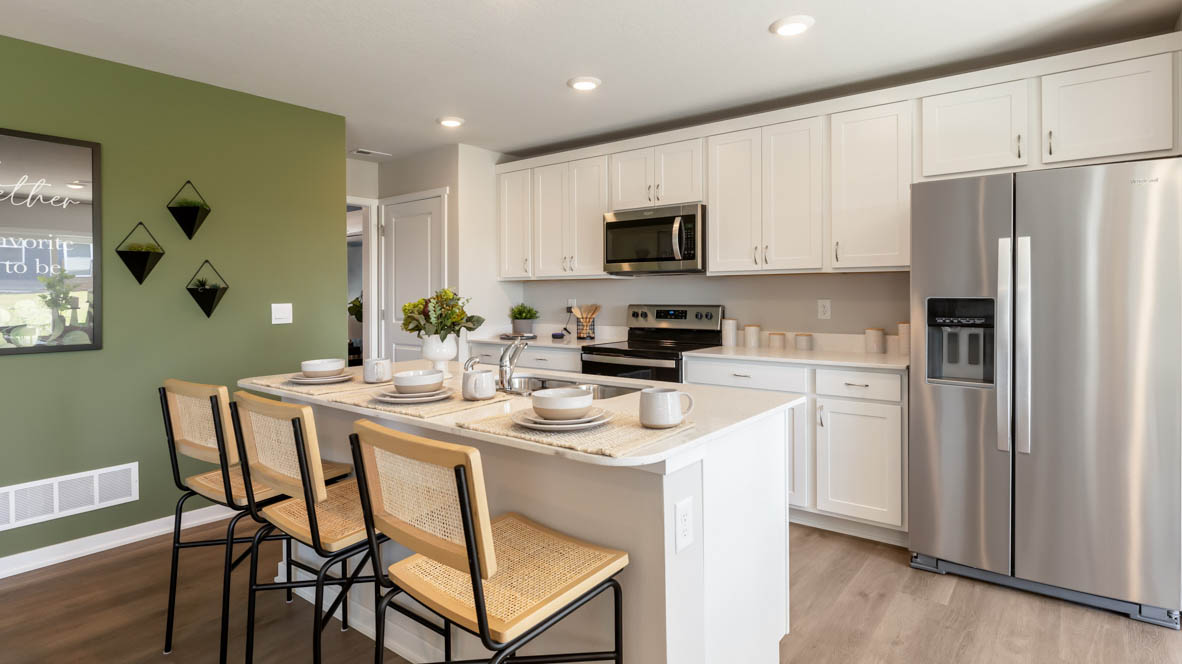 Kitchen with stainless steel appliances, quartz countertops, and white cabinetry