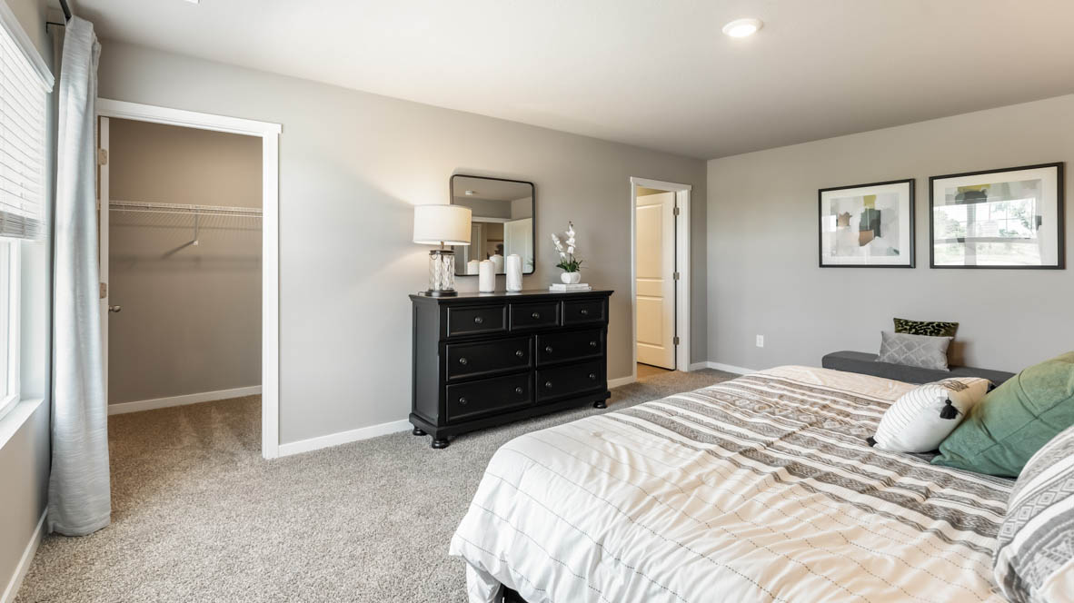 Spacious primary suite with natural light, attached bathroom, & walk in closet