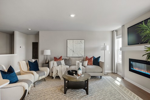 Interior view of a staged Hamilton with two large couches circled around the fireplace