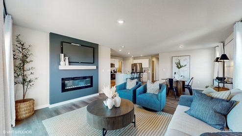 Living room with accent wall and fireplace in the abbott in American Prairie