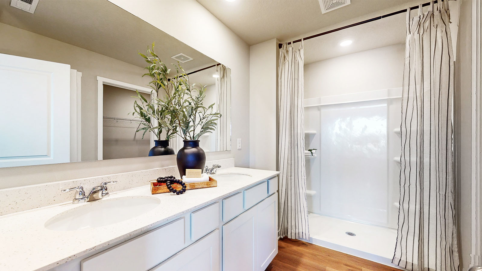 Spacious bathroom with white cabinetry and double sinks