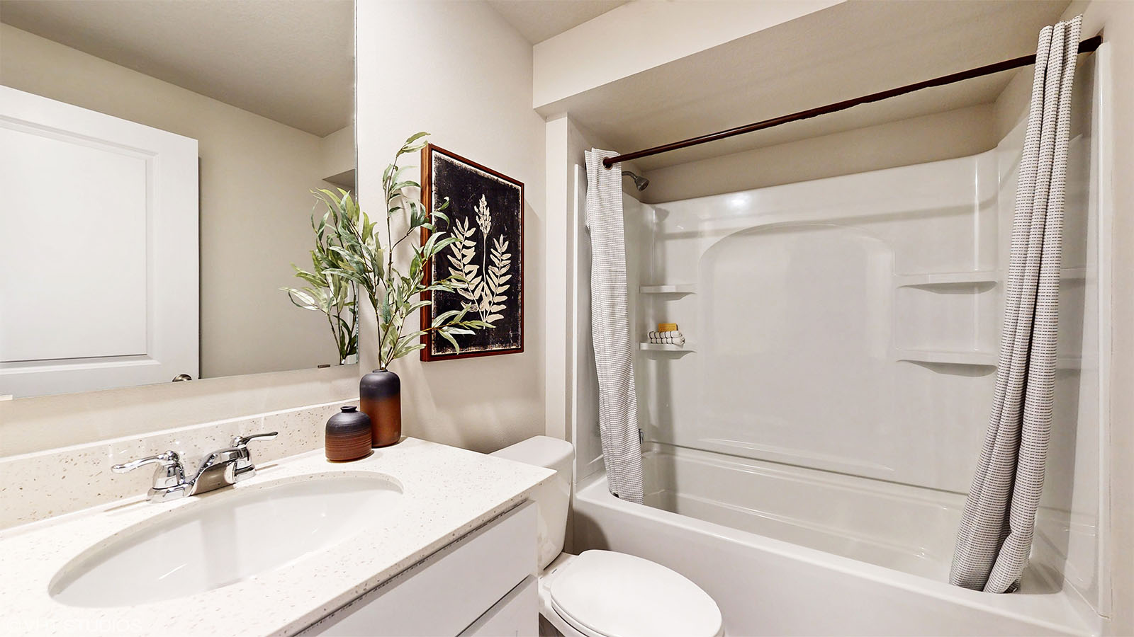 Bathroom with tub and shower combo, quartz countertops, and white vanity