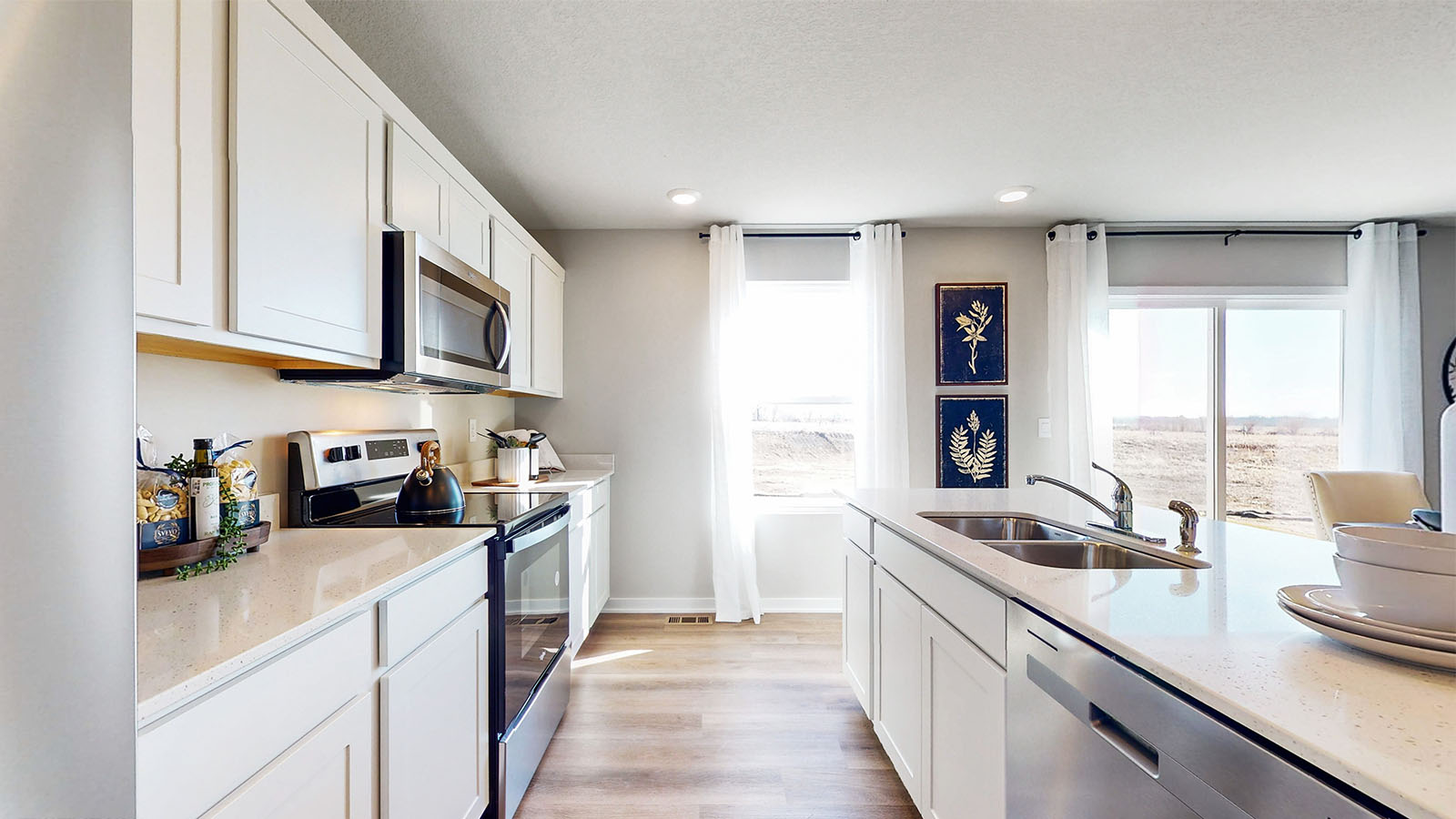 Kitchen with stainless steel appliances, quartz countertops, and white cabinetry