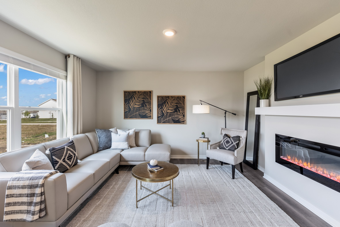 Living room in the Bellhaven with large sectional couch, coffee table and a fireplace