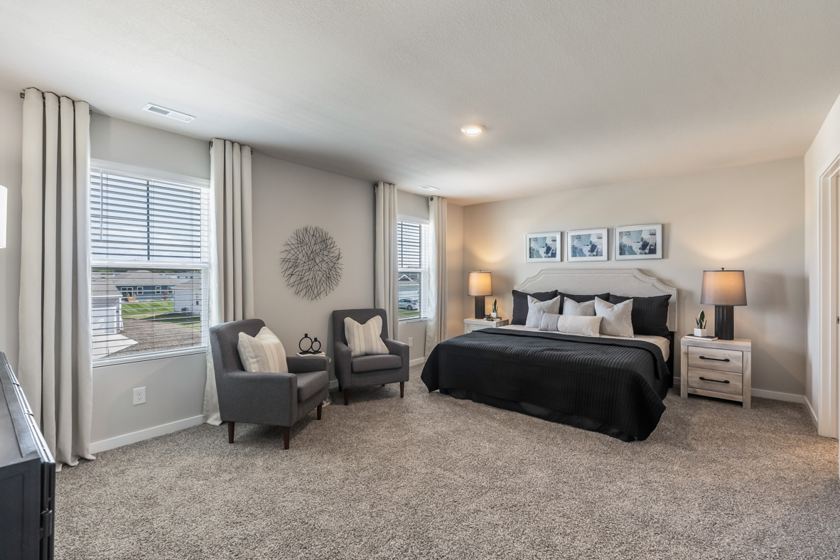 Spacious primary bedroom in the bellhaven with a king bed, seating area, and nightstands