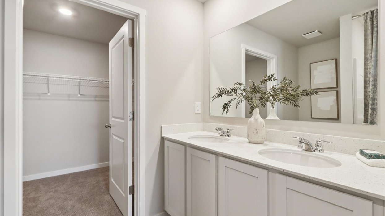 primary bathroom with large mirror and dual sinks