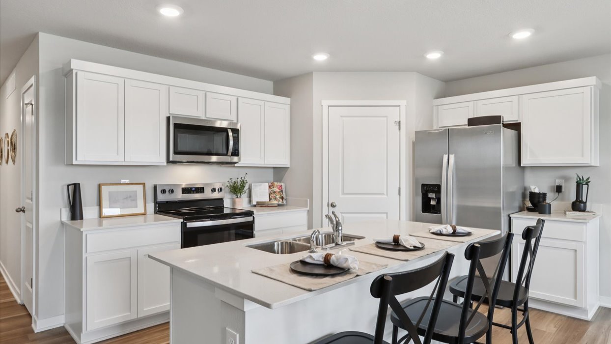 white modern kitchen with quartz countertops and stainless-steel appliances