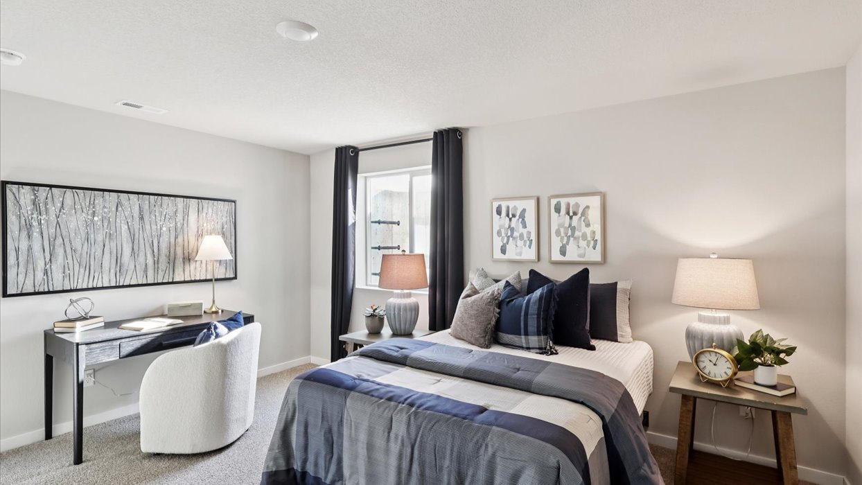 Private lower-level bedroom with natural light and functional storage space.