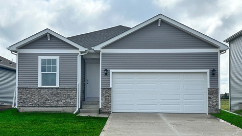 a single story home with grey siding and white trimming with stone half-way up the front of the house.