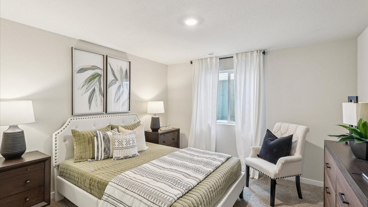 Private lower-level bedroom with natural light and functional storage space.