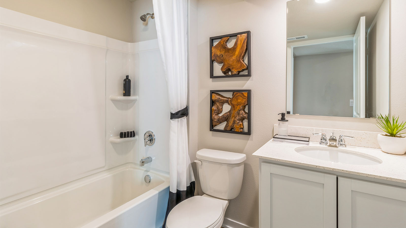 Basement full bathroom with vanity, white cabinetry, and tub-shower combo