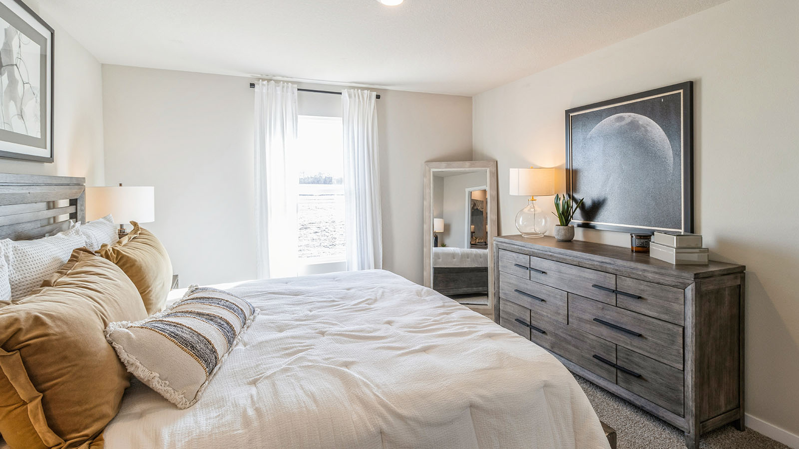 Primary bedroom with wide window, soft exterior light, and transitional flow