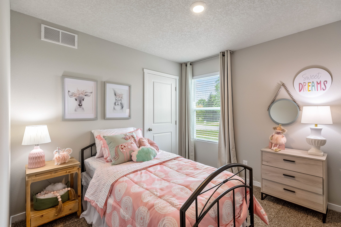 Third bedroom in the Roland decorated with cute animals and a pink theme that boasts a twin bed, nightstand, and dresser.