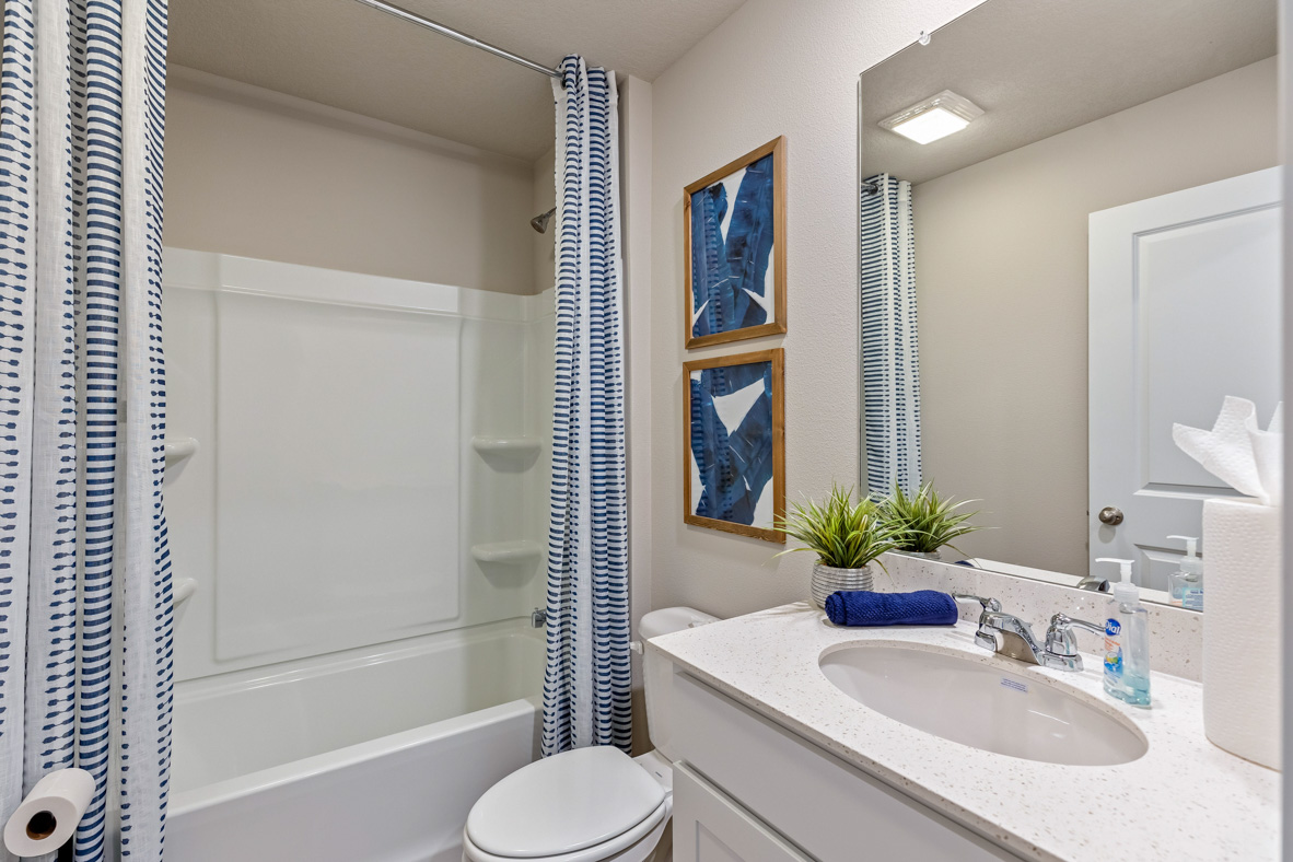Secondary bathroom with a single vanity and tub-shower combo in the Roland.