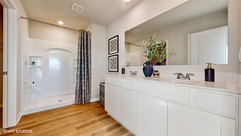 primary bathroom in the neuville with dual sinks and walk-in shower