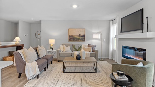 spacious living room with two grey couches and brown coffee table