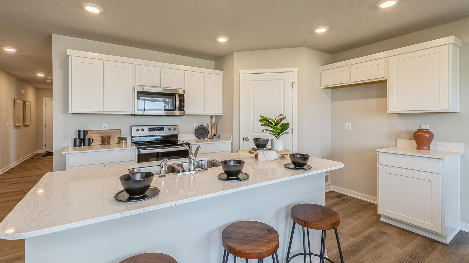 Kitchen with stainless steel appliances, quartz countertops, and white cabinetry
