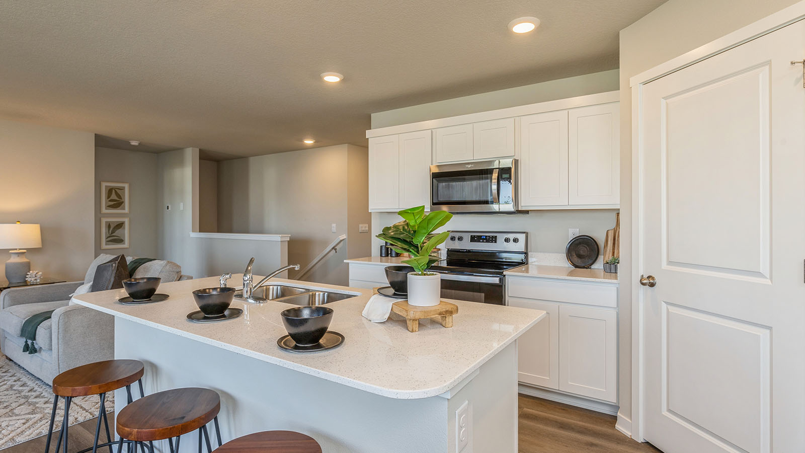 Kitchen with stainless steel appliances, quartz countertops, and white cabinetry