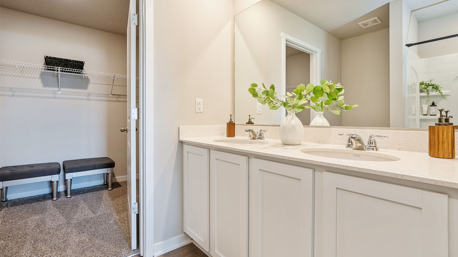 Spacious bathroom with white cabinetry and double sinks