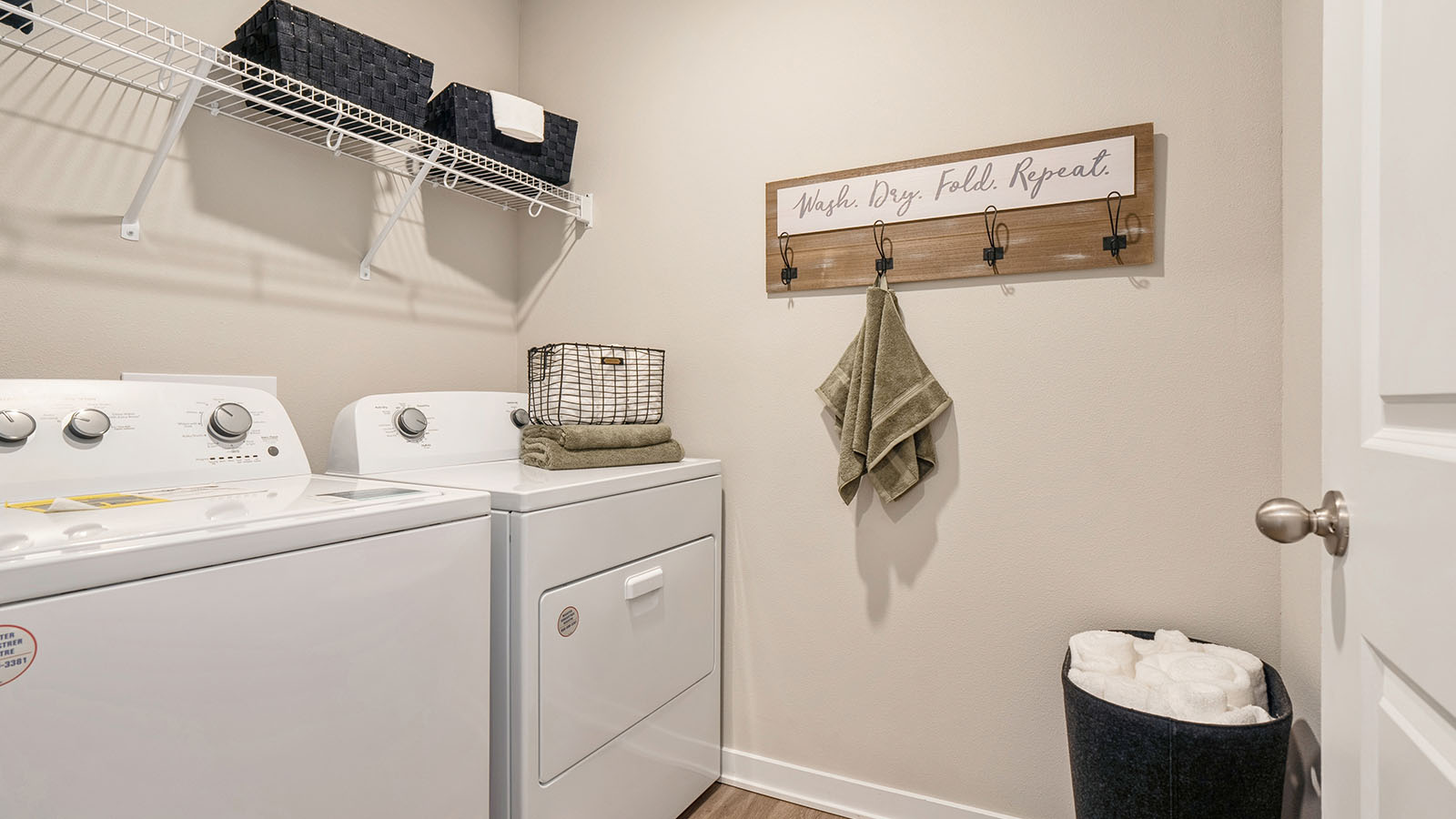 Dedicated laundry room with built-in shelving and utility connections.