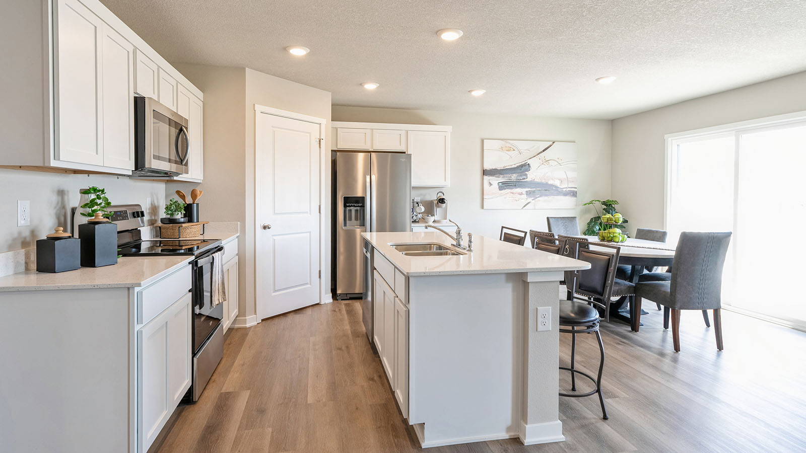 Kitchen with stainless steel appliances, quartz countertops, and white cabinetry