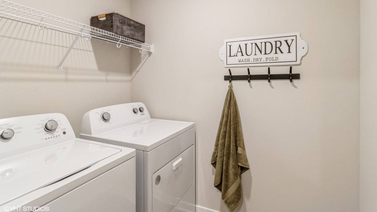 Dedicated laundry room with built-in shelving and utility connections.
