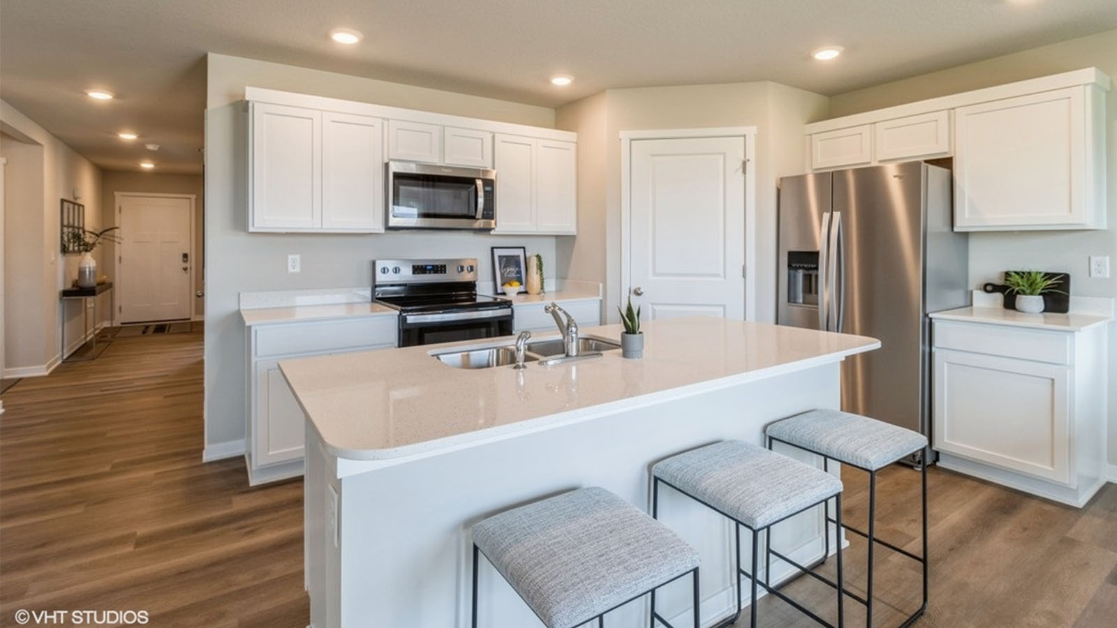 Kitchen with stainless steel appliances, quartz countertops, and white cabinetry