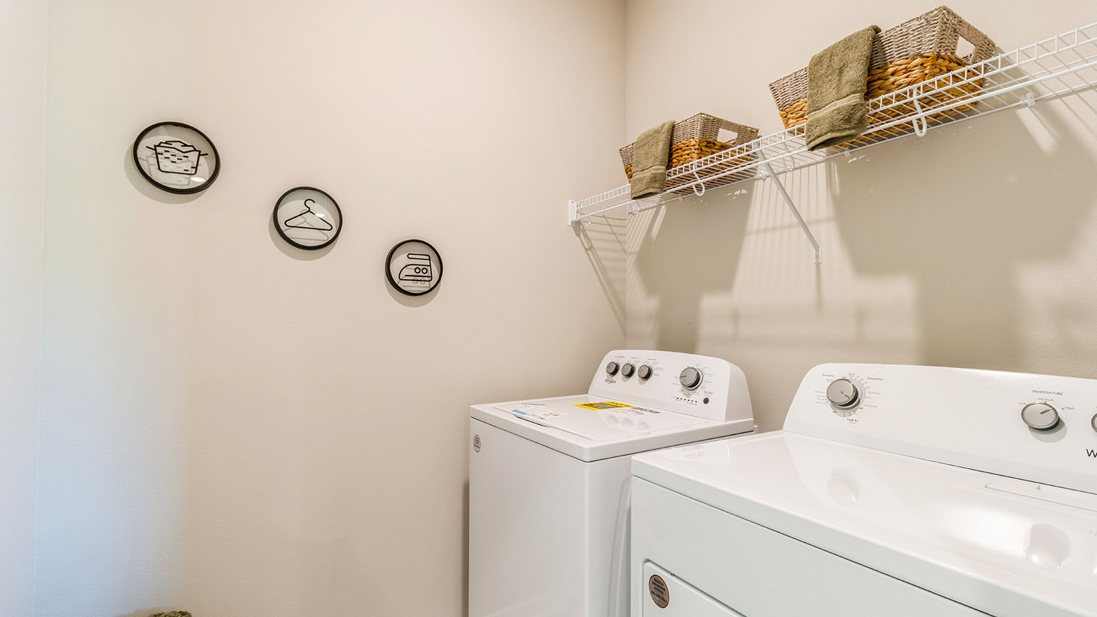 Dedicated laundry room with built-in shelving and utility connections.