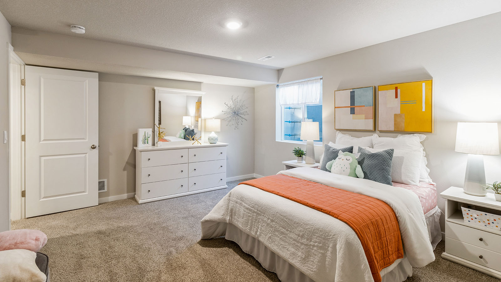 Private lower-level bedroom with natural light and functional storage space.
