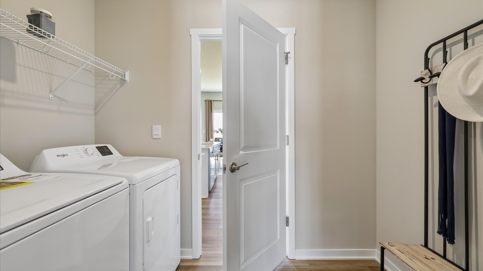 Dedicated laundry room with built-in shelving and utility connections.