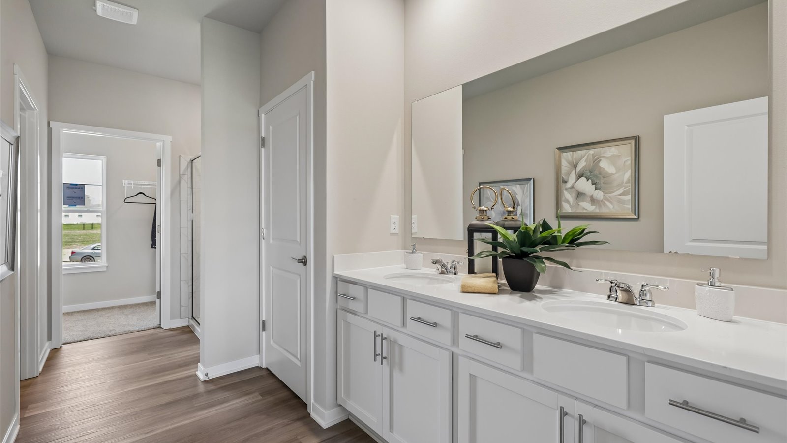 Spacious primary bathroom featuring dual vanities, modern fixtures, and a walk-in shower.