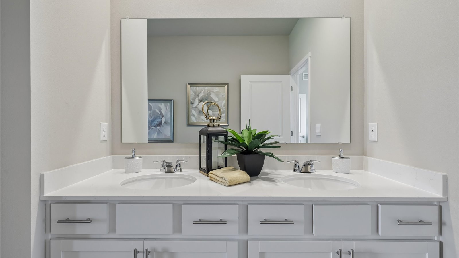 Spacious primary bathroom featuring dual vanities, modern fixtures, and a walk-in shower.