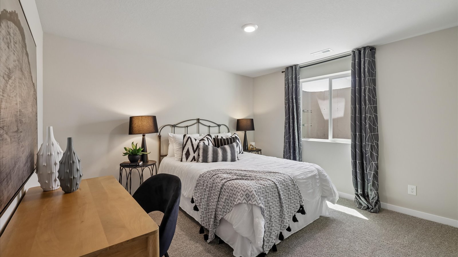 Private lower-level bedroom with natural light and functional storage space.