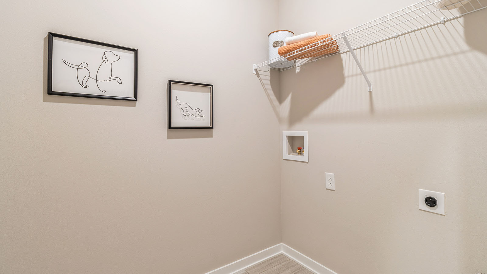 Dedicated laundry room with built-in shelving and utility connections.