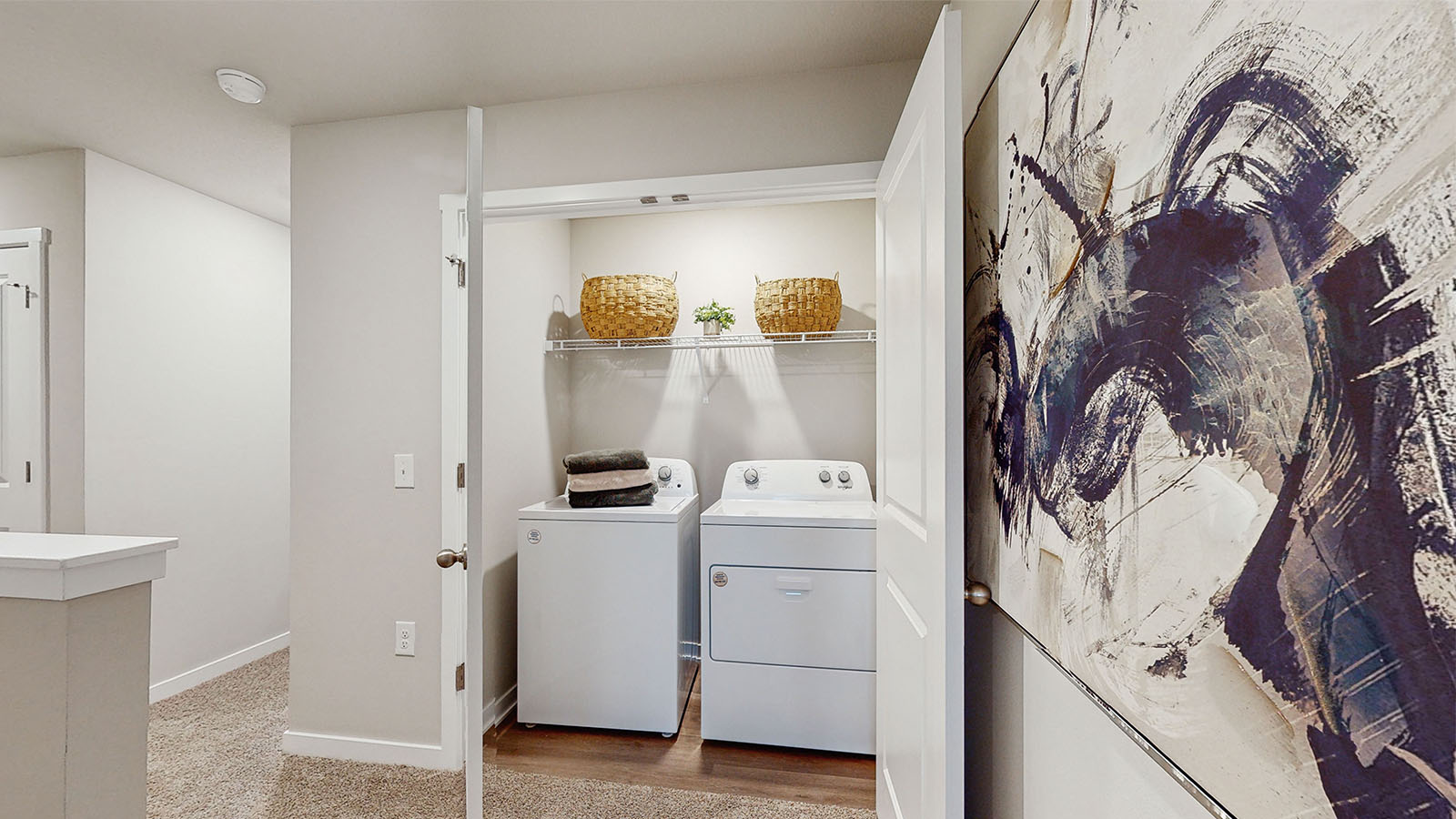 Cozy laundry space with natural light, a washer and dryer, and shelving for supplies.