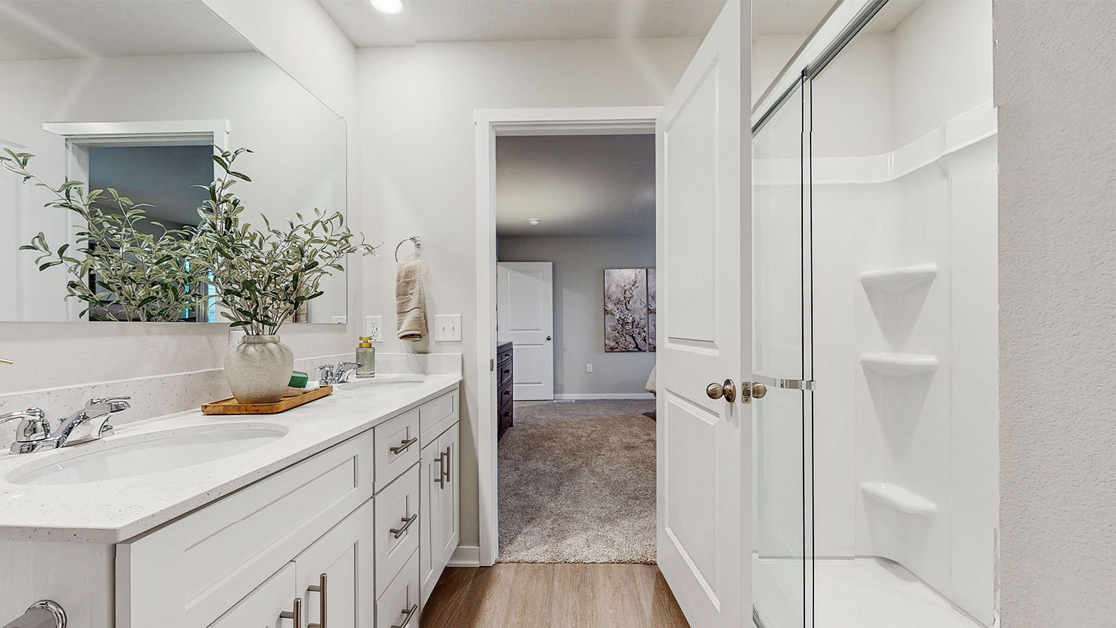 Spacious primary bathroom featuring dual vanities, modern fixtures, and a walk-in shower.