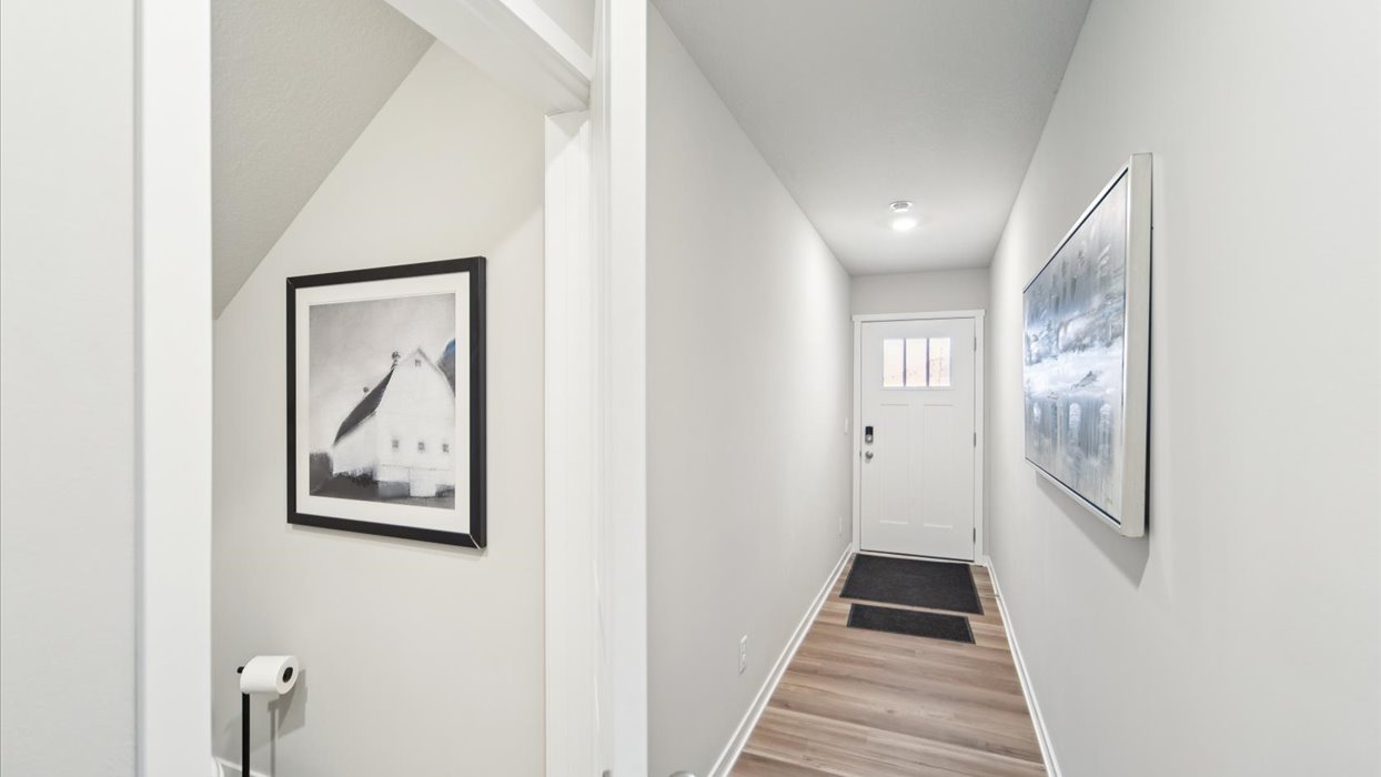 Welcoming townhouse entry hall with a half bathroom tucked just off the main walkway.