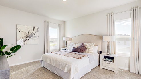 Primary bedroom with a large bed, two nightstands, and a dresser.