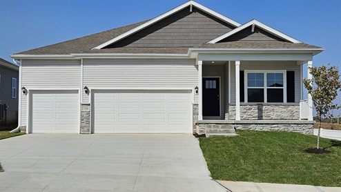 Fairfield with grey siding, stone, covered front porch and 3 car garage